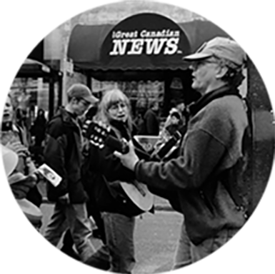 VFSS members singing and playing guitar during a street performance, sharing folk music with the public.
